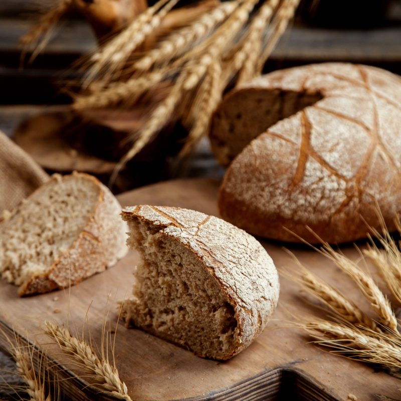 organic brown bread slice placed on wooden board in rustic style