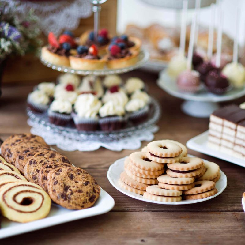 table-with-various-cookies-tarts-cakesxc-cupcakes-an-PARM8L9